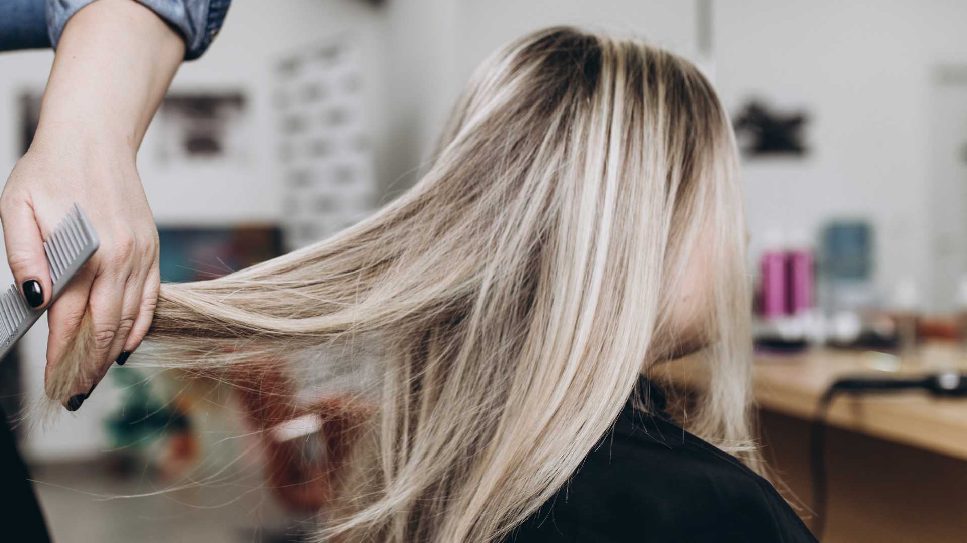 Stylist performing a detailed trim on a woman's short haircut